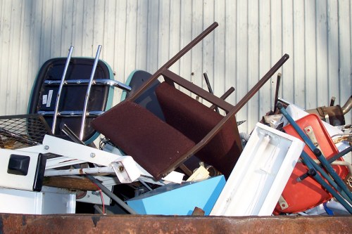Skip hire vehicle parked outside a London building with staff preparing equipment